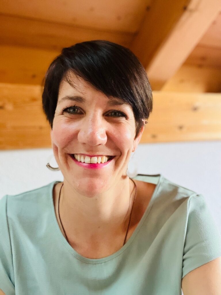 Frau mir grünem Shirt in Zimmer mit Holzdecke